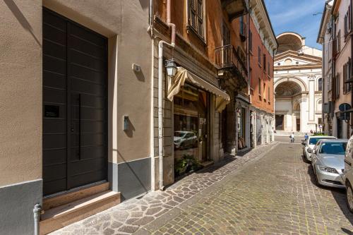 a cobblestone street in a city with buildings at Residenza San Longino in Mantova