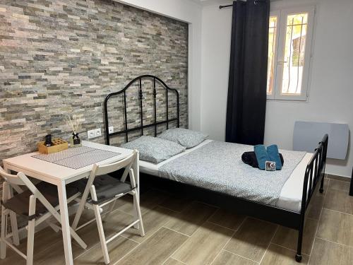 - une chambre avec un lit, une table et un mur en briques dans l'établissement Villa Évasion &3 le luxe au bord de l'eau, à Nice