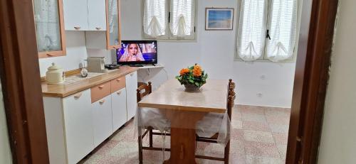 a kitchen with a table and a tv on a counter at casa al mare kalispera in Marina di Mancaversa