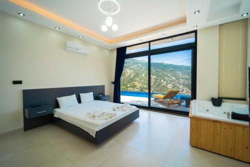 a bedroom with a bed and a tub and a large window at Villa Huzurlu in Kaş