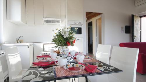 a dining room table with a vase of flowers on it at Capalbio - Retreat in Capalbio