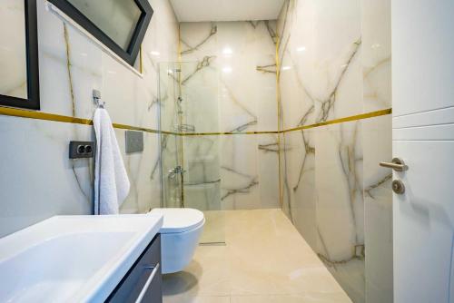 a bathroom with a shower and a toilet and a sink at Villa Huzurlu in Kaş