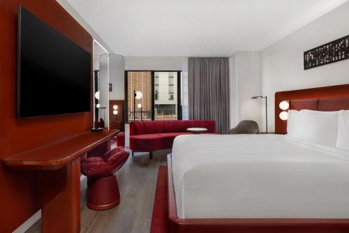 a hotel room with a bed and a tv at Revery Toronto Downtown, Curio Collection by Hilton in Toronto