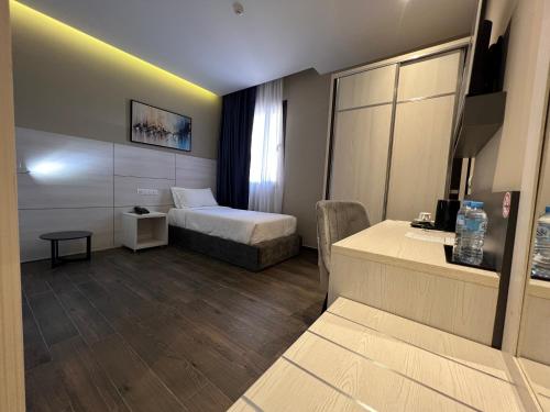a small hotel room with a bed and a desk at Hôtel Ben Aouda & Spa in Tipaza