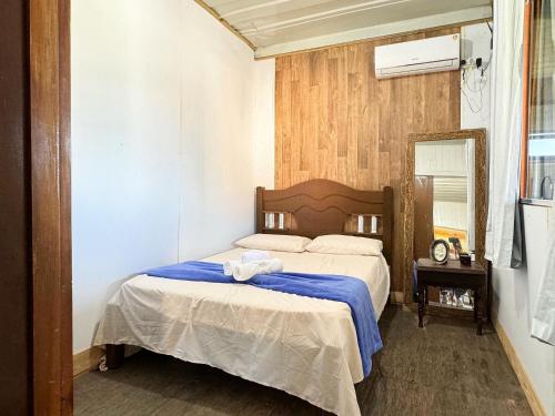 a bedroom with a bed with a blue blanket at Contêiner Exclusivo - Praia da Gamboa - GAR001 in Gamboa
