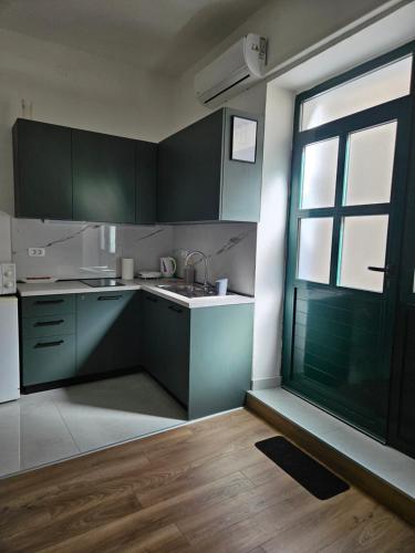 a kitchen with green cabinets and a large window at Apartment Marin in Split