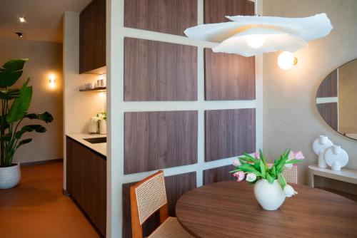 - une table à manger avec un vase blanc dans l'établissement Cà Bèla - Susa, à Milan