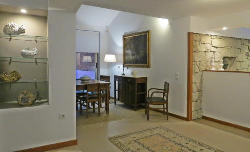 a dining room and living room with a table and chairs at Casa do O - Alojamento Local in Tábua
