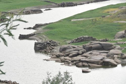 a river with a bunch of rocks in the water at Casa do O - Alojamento Local in Tábua