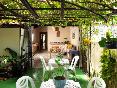 un patio con mesa, sillas y plantas en Pousada Residencial Porto de Galinhas en Porto De Galinhas