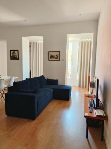 a living room with a blue couch and a table at Casa Irene in Aveiro