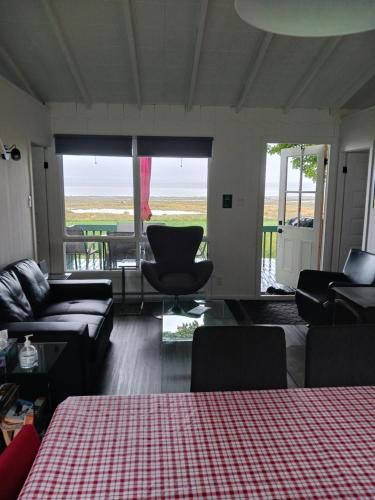 a living room with a couch and chairs and a table at Maison Marcotte in Saint-Michel