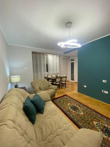a large bed in a living room with a couch at Cozy Central Apartment in Tetovo