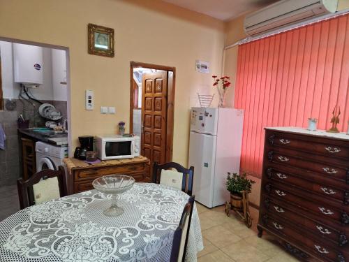 Una cocina con una mesa y un refrigerador blanco. en Heart of Balchik, en Balchik