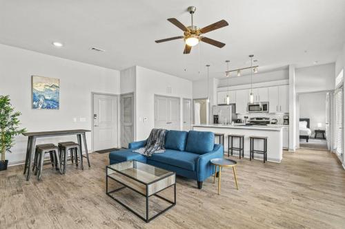 a living room with a blue couch and a kitchen at LUX 2B2B with Pool & Parking near the Heart of Austin in Austin