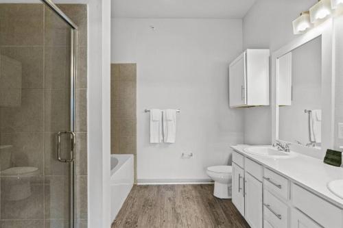 a white bathroom with a toilet and a shower at LUX 2B2B with Pool & Parking near the Heart of Austin in Austin