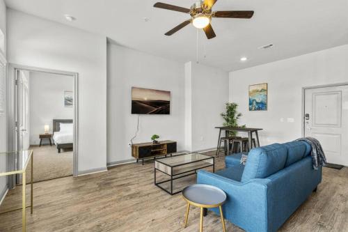 a living room with a blue couch and a ceiling fan at LUX 2B2B with Pool & Parking near the Heart of Austin in Austin