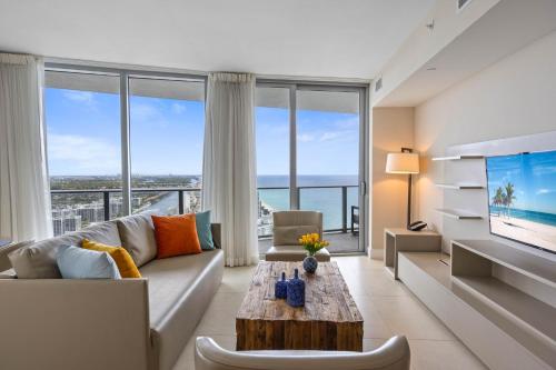 a living room with a couch and a table at Corner condo, Wraparound Balcony Ocean and City Views at LYFE Resort in Hollywood