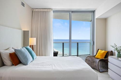 a bedroom with a bed and a large window with the ocean at Corner condo, Wraparound Balcony Ocean and City Views at LYFE Resort in Hollywood