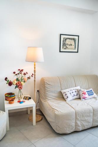 a living room with a couch and a table with a lamp at Mimis & Connie 1 in Karpathos Town