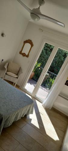 une chambre avec un lit et deux fenêtres dans l'établissement Appartement avec jardin et piscine, à Roquebrune-sur Argens