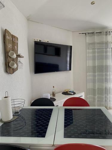 a living room with a table with a tv on the wall at Apartments Ema in Lovran