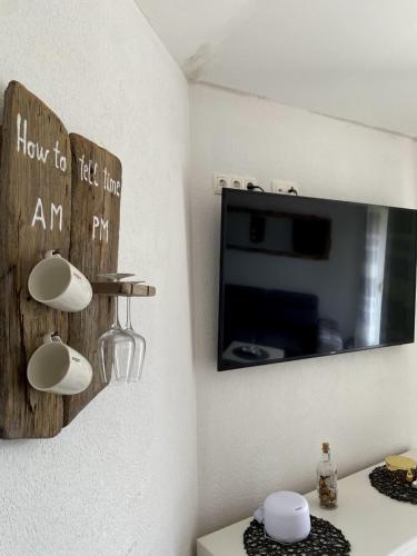 a living room with a tv and a table with at Apartments Ema in Lovran