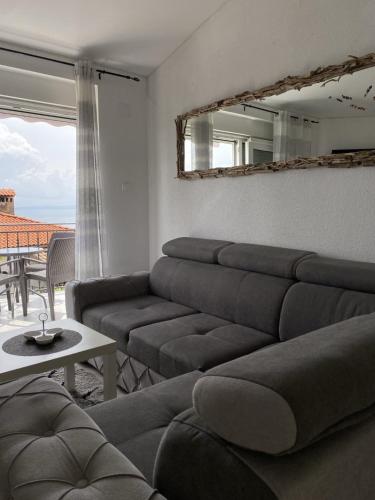 a living room with a couch and a mirror at Apartments Ema in Lovran
