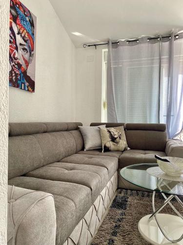 a living room with a couch and a glass table at Apartments Ema in Lovran