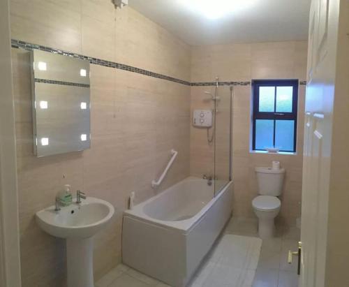 a bathroom with a tub and a sink and a toilet at Entire home in Belmullet in Belmullet