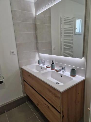 une salle de bain avec un lavabo blanc et un miroir dans l'établissement Maison neuve clim 400m plage, à Saintes-Maries-de-la-Mer