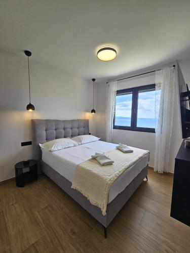 a bedroom with a large bed and a large window at Casa Miele in Omiš