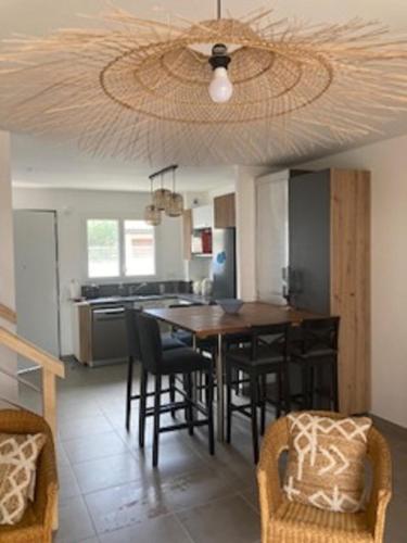 une cuisine avec une table et des chaises et un plafond dans l'établissement Maison neuve clim 400m plage, à Saintes-Maries-de-la-Mer
