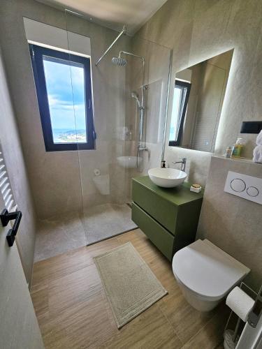 a bathroom with a toilet and a sink and a shower at Casa Miele in Omiš
