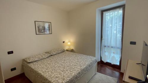 a bedroom with a bed and a large window at Incantevole appartamento in Moniga