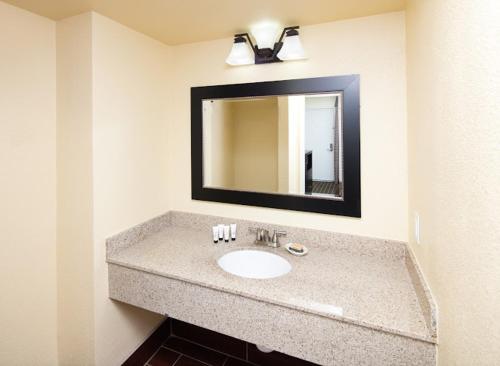 a bathroom with a sink and a mirror at GuestPlace Inn & Suites in Redding