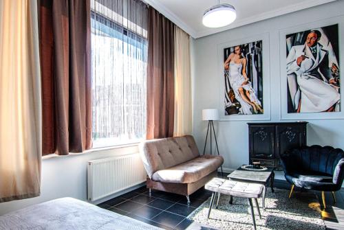 a living room with a couch and a chair at Apartament Pasaż in Giżycko