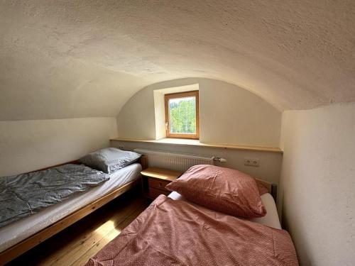 two beds in a small room with a window at Ferienhaus Kirchberg am Wechsel in Tratten
