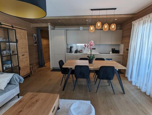 una cucina e una sala da pranzo con tavolo e sedie di Appartement de standing Auron ad Auron