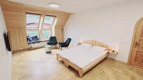 a bedroom with a bed and two chairs in it at Nidos burė in Nida