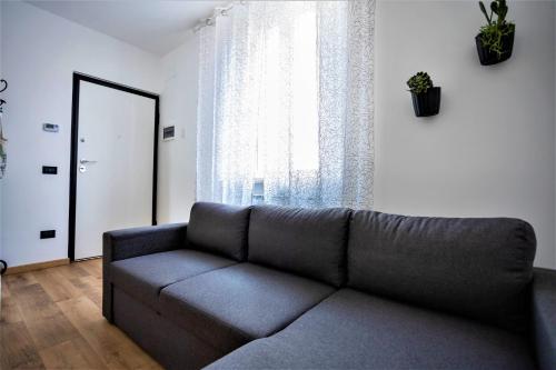 Una sala de estar con un sofá y una ventana. en Lagom Comfort Home, en Ancona