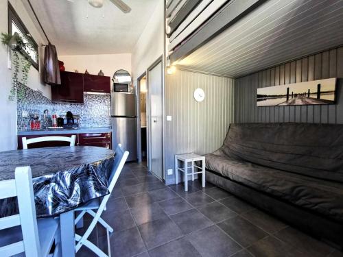 une chambre avec un canapé et une table dans une cuisine dans l'établissement Résidence Cabestans Et - Studio 071, au Barcarès