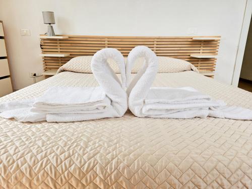 two swans towels sitting on top of a bed at Narissara apartment in La Spezia