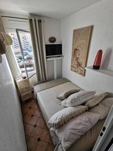 une petite chambre avec deux lits et une fenêtre dans l'établissement Résidence Le Mail A La Plage - Studio pour 4 Personnes 091, à Leucate