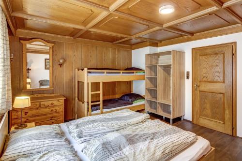a bedroom with bunk beds and a wooden ceiling at Ludwighaus in Neukirchen am Großvenediger
