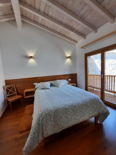 ein Schlafzimmer mit einem Bett und einem großen Fenster in der Unterkunft CASA DO EIRÓ in Lobios