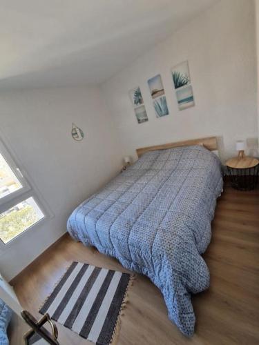 une chambre avec un lit avec une couverture bleue dans l'établissement Appartement Cap d'Agde avec vue mer, au Cap d'Agde