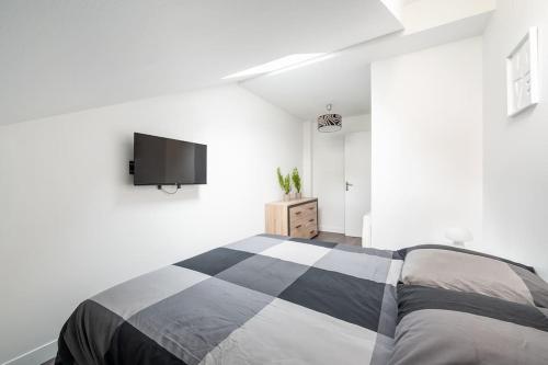 a bedroom with a bed and a tv on the wall at Maison en Centre-Ville - Neuilly in Neuilly-sur-Seine