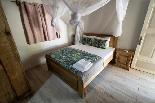 a small bedroom with a bed with a canopy at La Teranga Toubacouta in Bani