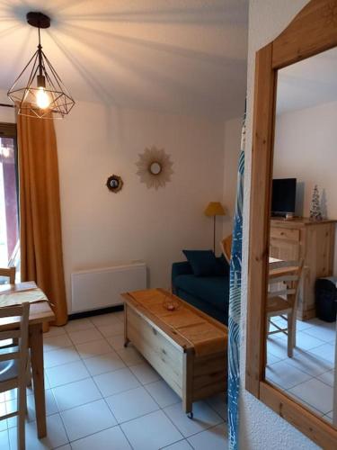 un salon avec un canapé bleu et une table dans l'établissement Appartement Cosy proche St lary et Loudenvielle, à Arreau